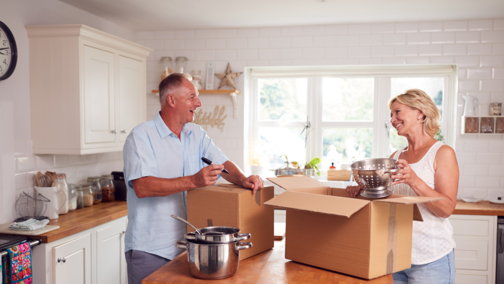 A senior man and a senior woman pack up a kitchen to prepare to move