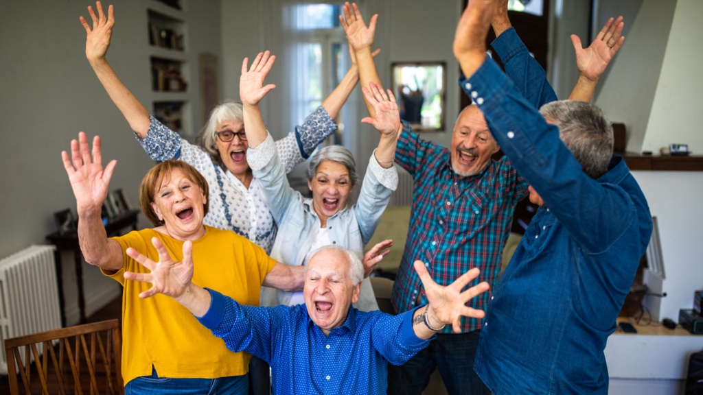 A group of seniors throw their hands in the air in excitement