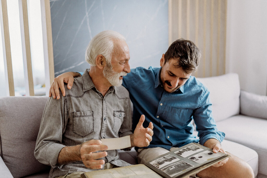 Father and son looking and old pictures in a scrapbook together on the couch